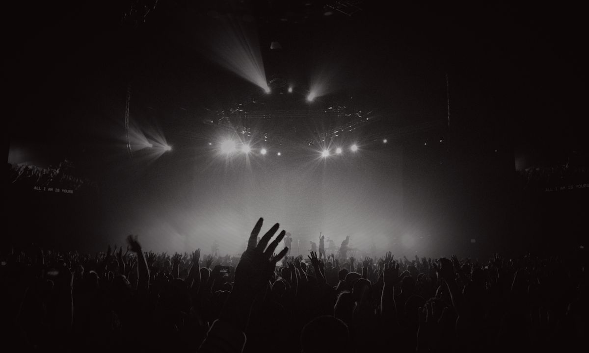 A festival crowd silhouetted against stage lighting