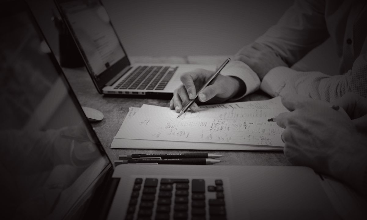 Two people working through a plan at a laptop
