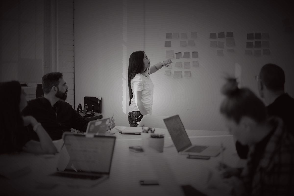 A small team working through a plan on a wall of notes