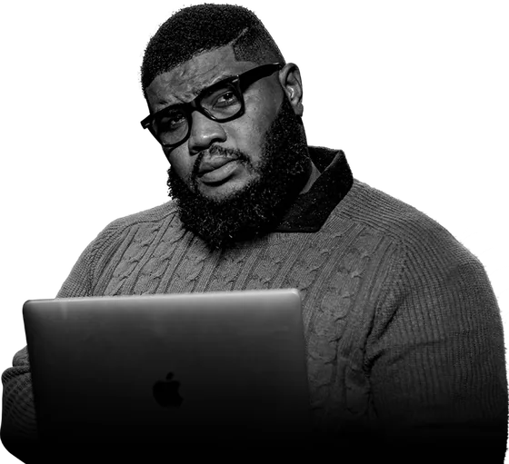 Kevin Eze working at a laptop, photographed in black and white